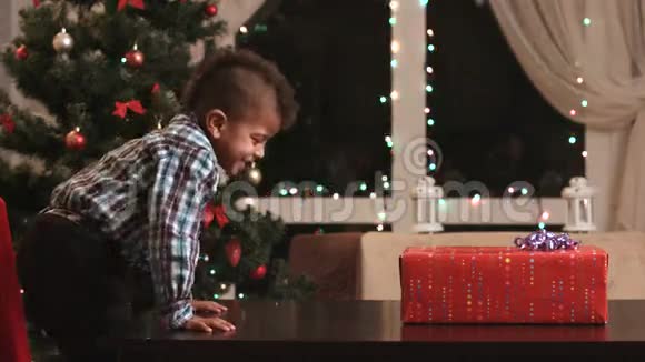 男孩在桌子上打开礼物视频的预览图