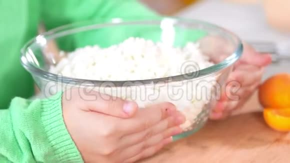 小女孩的手拿着一碗白奶酪放在桌子上视频的预览图