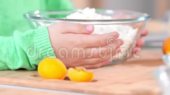 小女孩的手拿着一碗白奶酪放在桌子上视频的预览图