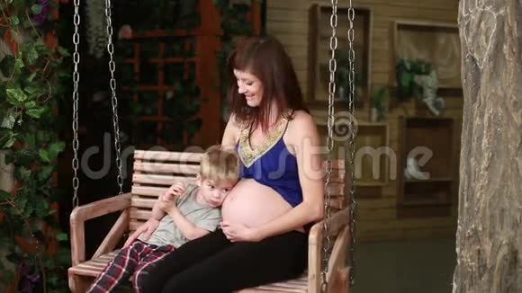 有大孩子的孕妇在秋千上视频的预览图