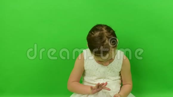 可爱的小女孩在色度键背景上阅读电子书穿着浪漫裙子的小女孩白色婚纱礼服视频的预览图