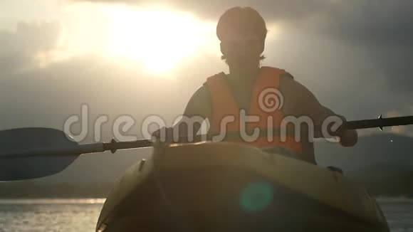 英俊的皮划艇在美丽的日落和水滴飞溅和镜头耀斑效果慢动作视频的预览图