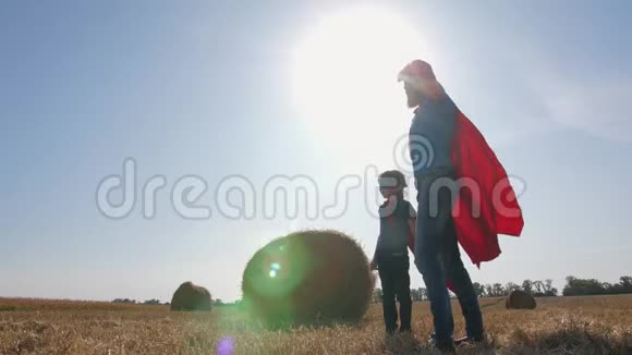 日落时分穿着超级英雄服装的父子视频的预览图