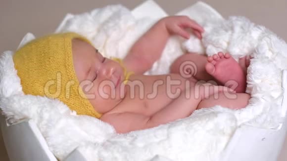 戴着黄色帽子睡觉的新生儿视频的预览图