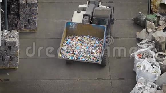 回收工厂院子里装有大勺分类垃圾的卡车视频的预览图