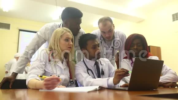 多种族的年轻医生团队在医疗办公室的笔记本电脑上工作视频的预览图