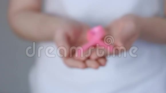 女士双手捧着粉红色乳腺癌意识丝带乳腺癌意识概念视频的预览图