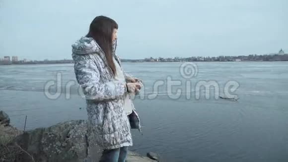 一位女士正在池塘旁边的老式复古风格相机上拍摄视频的预览图