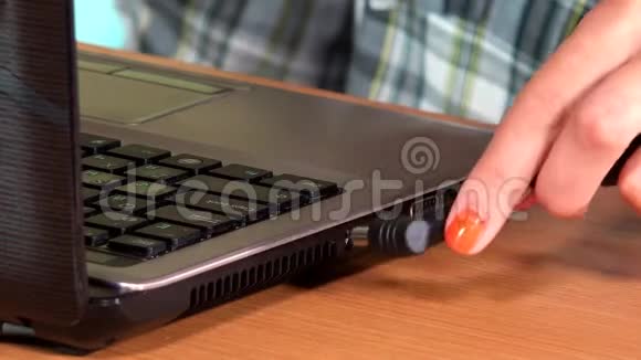 女性手插电源电缆笔记本电脑视频的预览图