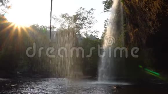 傍晚时分在丛林中的壮观瀑布下观看咖啡厅水在泳池中的瀑布穿过太阳湾视频的预览图