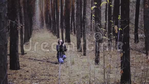 摄影师走过森林拍摄秋天的风景电影镜头慢镜头视频的预览图