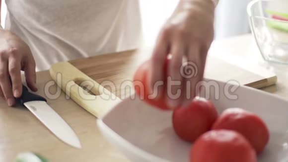女人在厨房慢动作的砧板上切番茄视频的预览图
