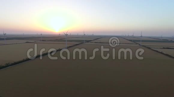 风力发电机与叶片可再生的风能资源在美丽的风景日落航空测量视频的预览图