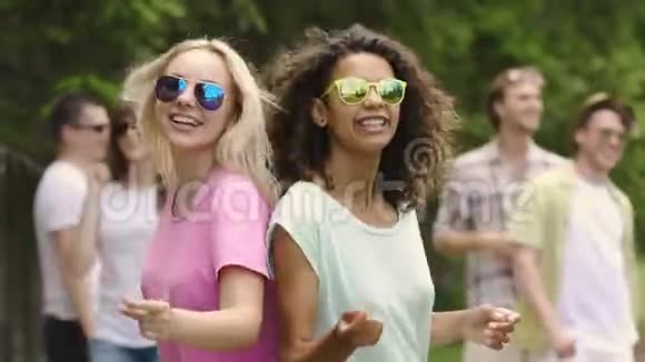 两个美丽的女孩微笑着和朋友在聚会上跳舞健康的生活方式视频的预览图