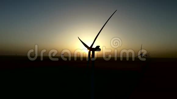 在宁静的夏季夜晚风电场上的风力涡轮机日落剪影航空测量视频的预览图