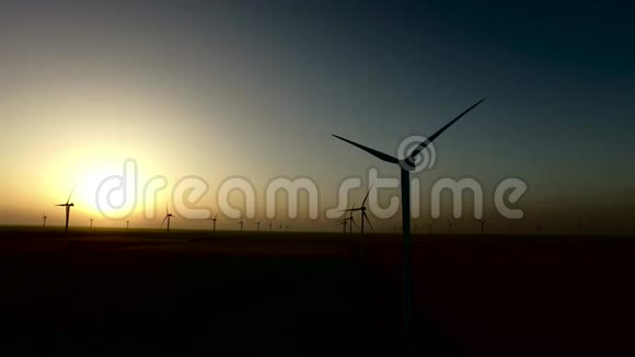 风力涡轮机再生能源在温暖的晚霞剪影航空测量视频的预览图