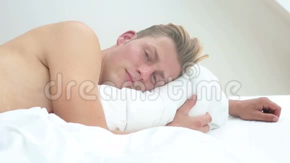 帅哥在床上醒来对着镜头微笑视频的预览图