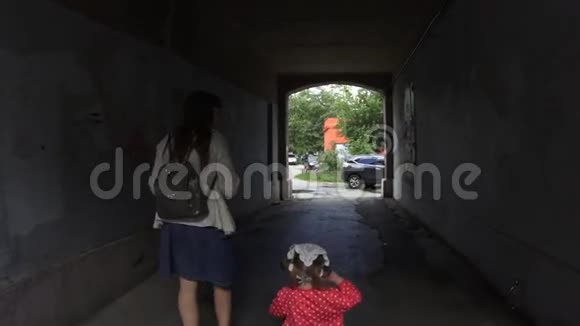 母亲带着女儿骑着三轮车穿过拱门动作缓慢视频的预览图