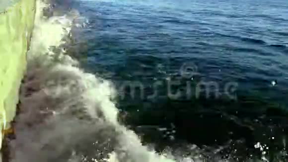 晴天时海浪冲击石墩视频的预览图