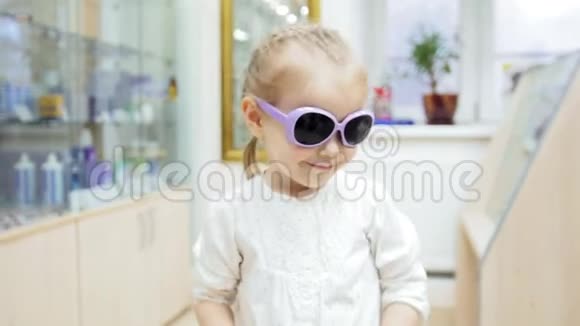 小女孩尝试用蓝色眼镜在诊所购物视频的预览图