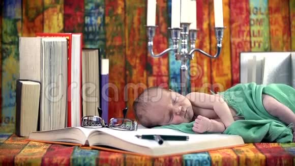 婴儿睡在一套有书和烛台的电视机上视频的预览图