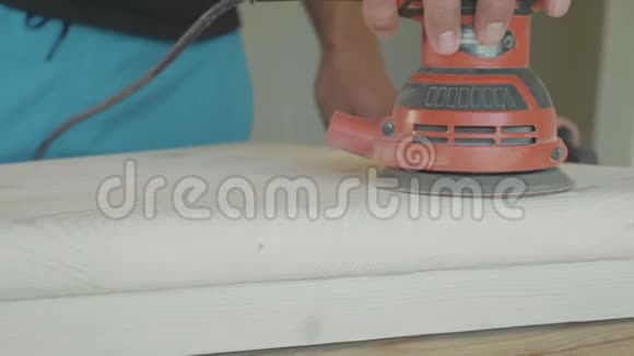 木匠用电动砂光机打磨楼梯的木制台阶特写视频的预览图