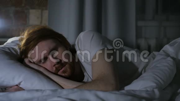 不舒服的红发胡子男晚上睡在床上不安视频的预览图