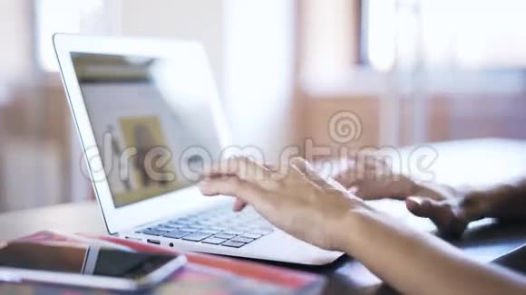 女人用手在办公室的笔记本电脑上打字视频的预览图