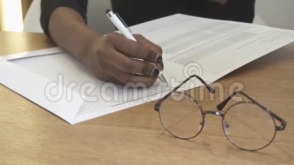 接待处的女孩正在填写表格中的信息非洲手的特写镜头眼镜视频的预览图