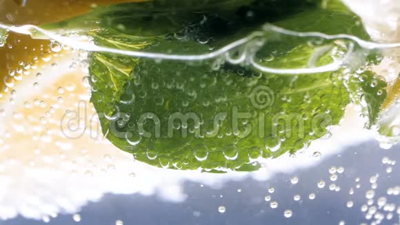 特写慢动作视频气泡漂浮在冰冷的柠檬水中视频的预览图