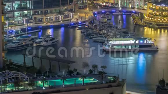 迪拜码头的海滨长廊和运河在夜晚临近的时候有豪华的摩天大楼和游艇阿拉伯联合酋长国视频的预览图