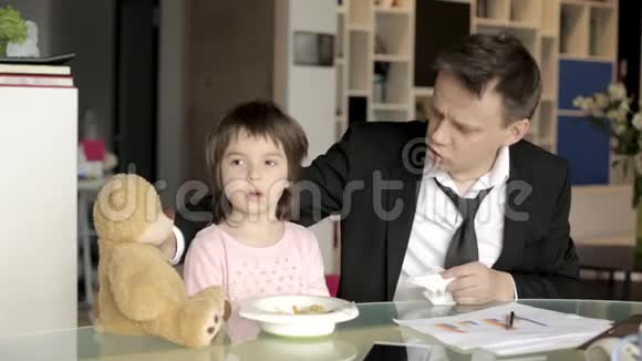 父亲穿着西装拿着文件给女儿喂食视频的预览图