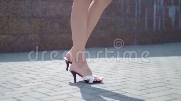 女人穿着高跟鞋在城市街道上散步稳定射击女性高腿部视频的预览图