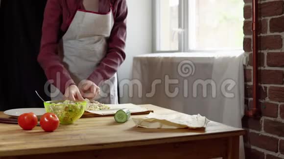 女性用手做皮塔和肉屑并在厨房添加蔬菜视频的预览图