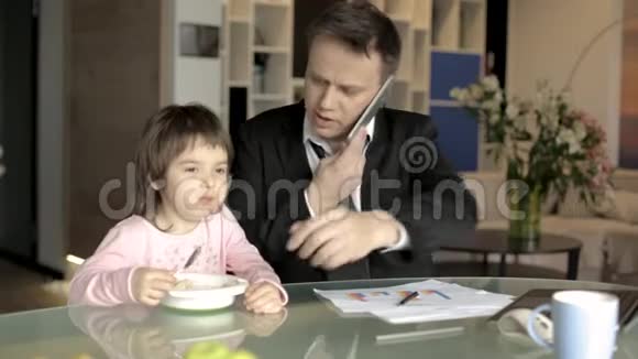 父亲穿着西装拿着文件给女儿喂食视频的预览图