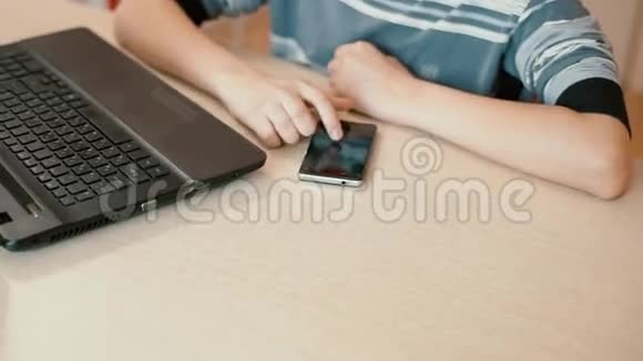 电脑桌上的男青年热情地在智能手机上打短信视频的预览图