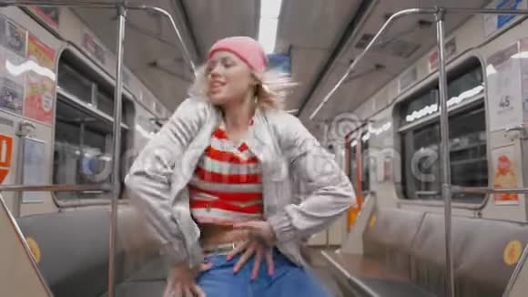 那个有趣的迷人的快乐的金发女孩在地铁的地铁里跳舞女人为成功而高兴视频的预览图