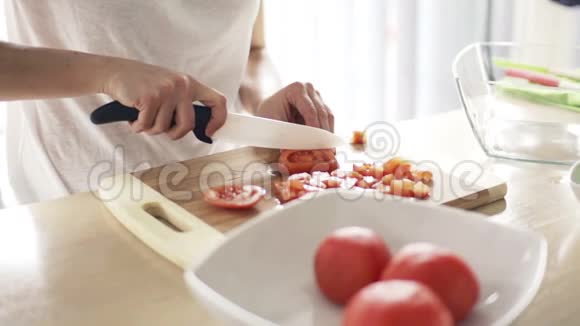 女人在厨房慢动作的砧板上切番茄视频的预览图