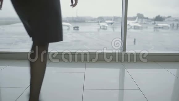 女商人穿高跟鞋带着行李在机场窗口附近视频的预览图