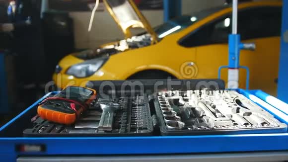 机械师修理汽车在金属工具箱前面车库服务视频的预览图