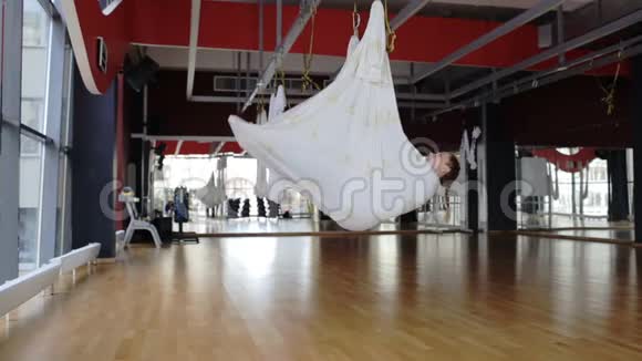 在宽敞的大厅里灵活的女人用重力表演杂技特技视频的预览图