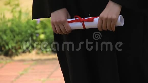 持有红丝带毕业证书的毕业生手毕业典礼视频的预览图