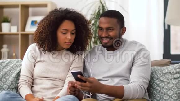 有智能手机和耳机的幸福夫妻视频的预览图