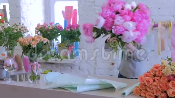 花商在花店用礼品纸包花视频的预览图