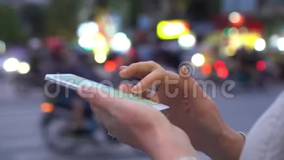 在城市中使用智能手机的亲密女性背景上轻快的路越南因为女人使用智能手机视频的预览图