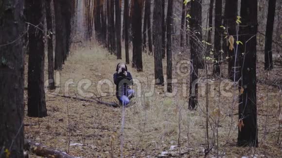 摄影师女孩拍摄秋天森林的照片第一场雪拍摄大自然的照片视频的预览图