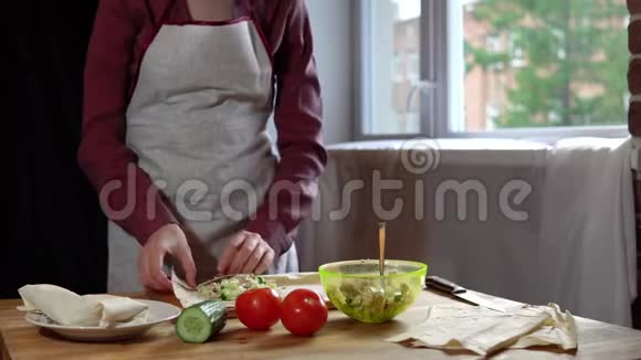 女性用手做皮塔和肉屑并在厨房添加蔬菜视频的预览图