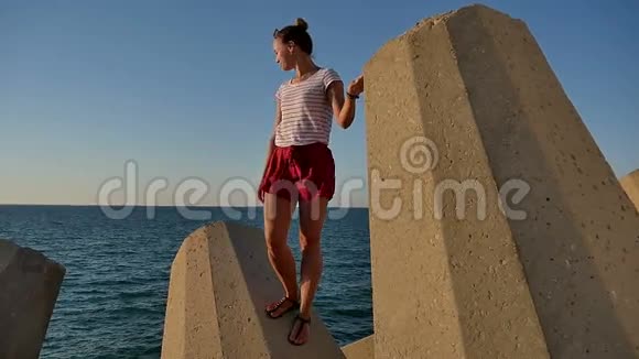 站在石块上看大海的漂亮女孩视频的预览图