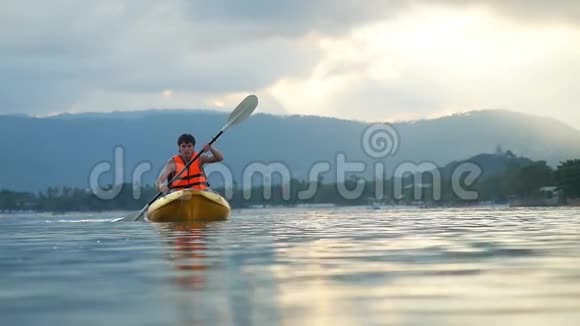 独木舟在美丽的日落和水滴飞溅愉快的暑假休息休闲娱乐视频的预览图