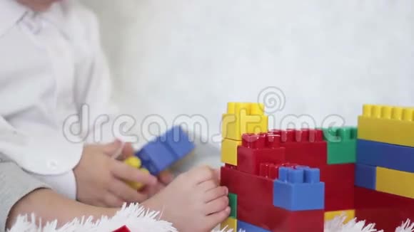 男孩用彩色积木在沙发上盖房子视频的预览图